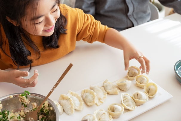 A young girl helping make dumplings.